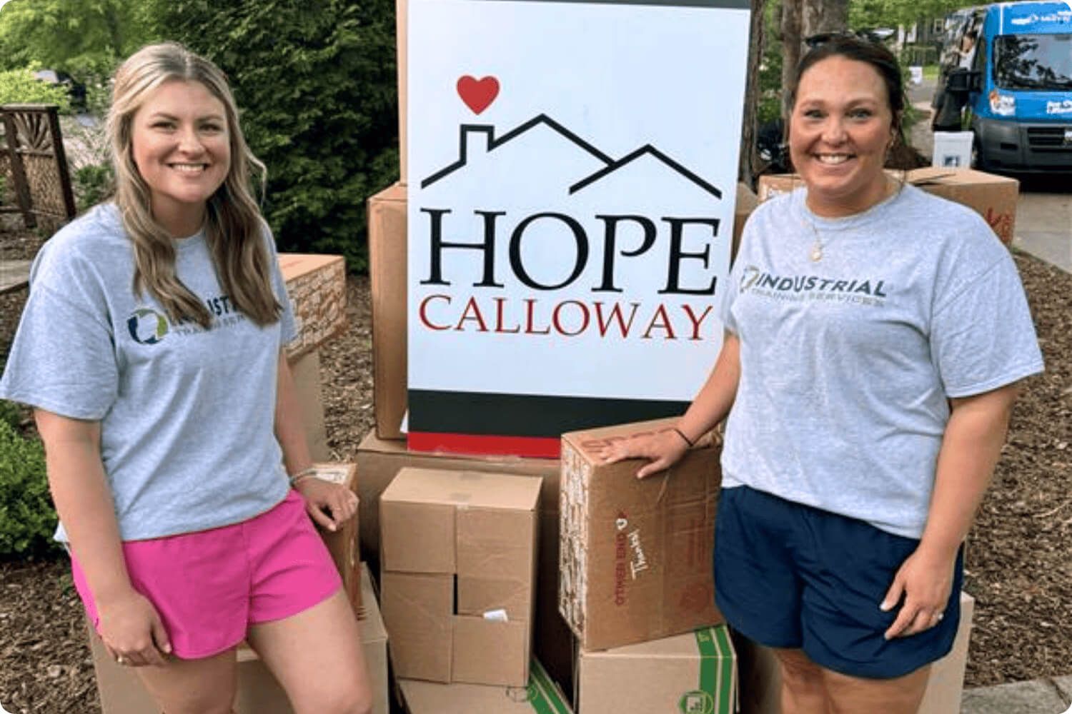 Photo of two employees in front of the HOPE Calloway sign