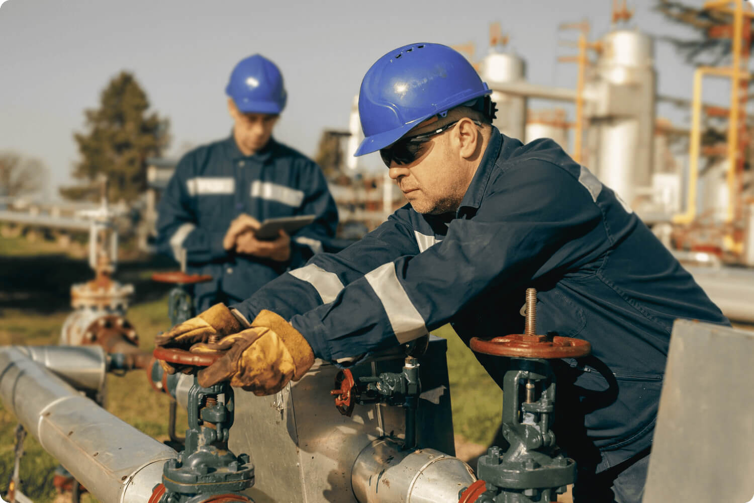 Man turning a valve on a pipeline